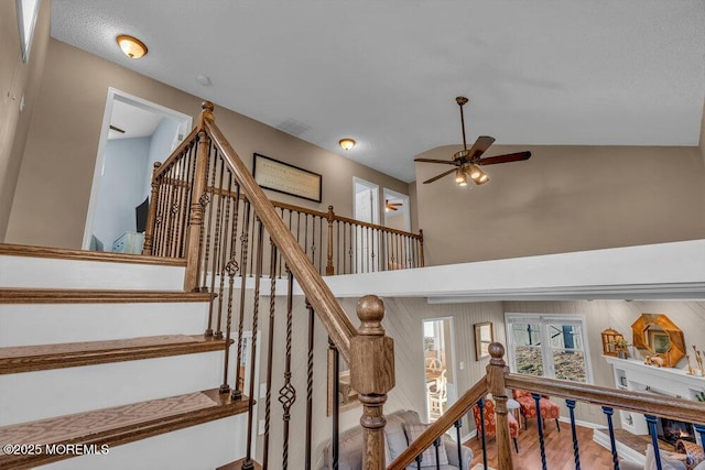 staircase featuring hardwood / wood-style flooring, a towering ceiling, and ceiling fan