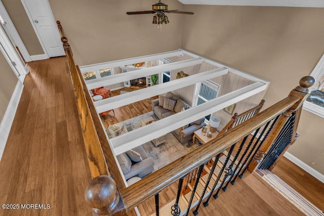 staircase with ceiling fan and wood-type flooring