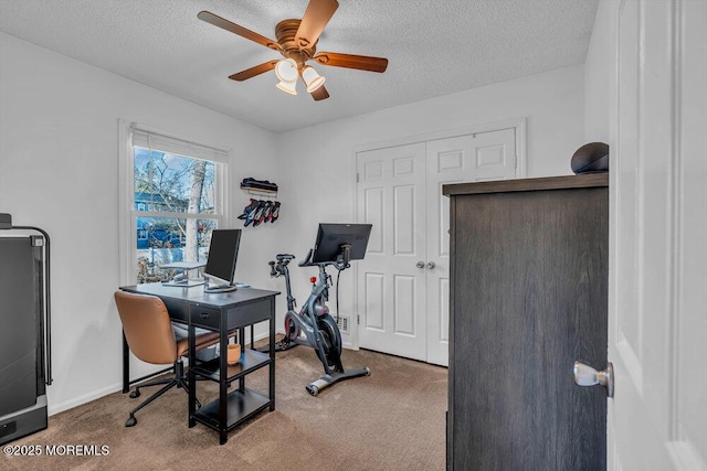 workout area with ceiling fan, carpet, and a textured ceiling