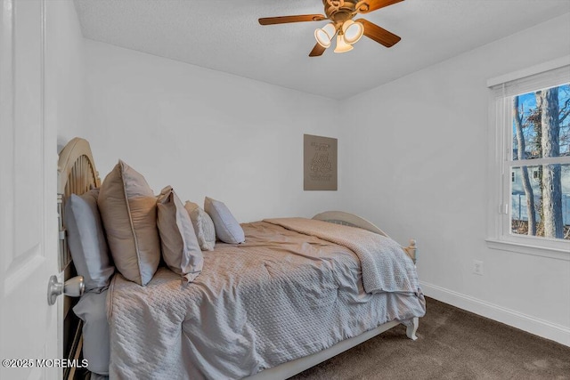 bedroom with ceiling fan, carpet, and a textured ceiling