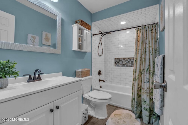 full bathroom featuring vanity, hardwood / wood-style flooring, shower / bath combination with curtain, and toilet