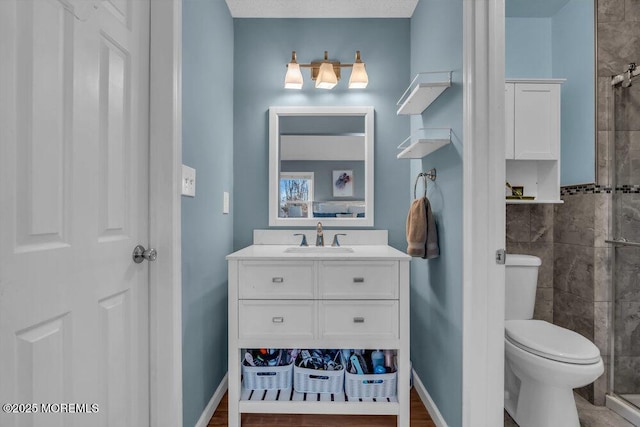 bathroom featuring vanity, toilet, tile walls, and walk in shower