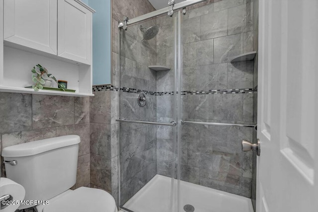 bathroom with tile walls, an enclosed shower, and toilet