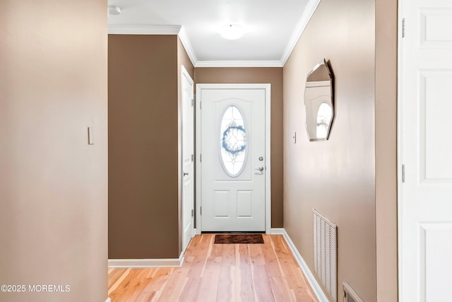 doorway featuring light wood finished floors, baseboards, visible vents, and ornamental molding