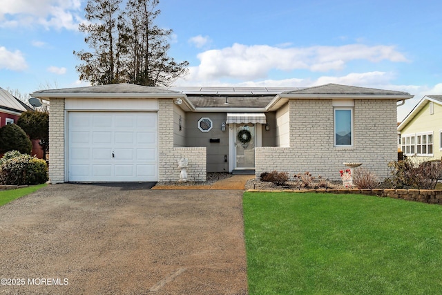 ranch-style home featuring aphalt driveway, brick siding, solar panels, an attached garage, and a front yard