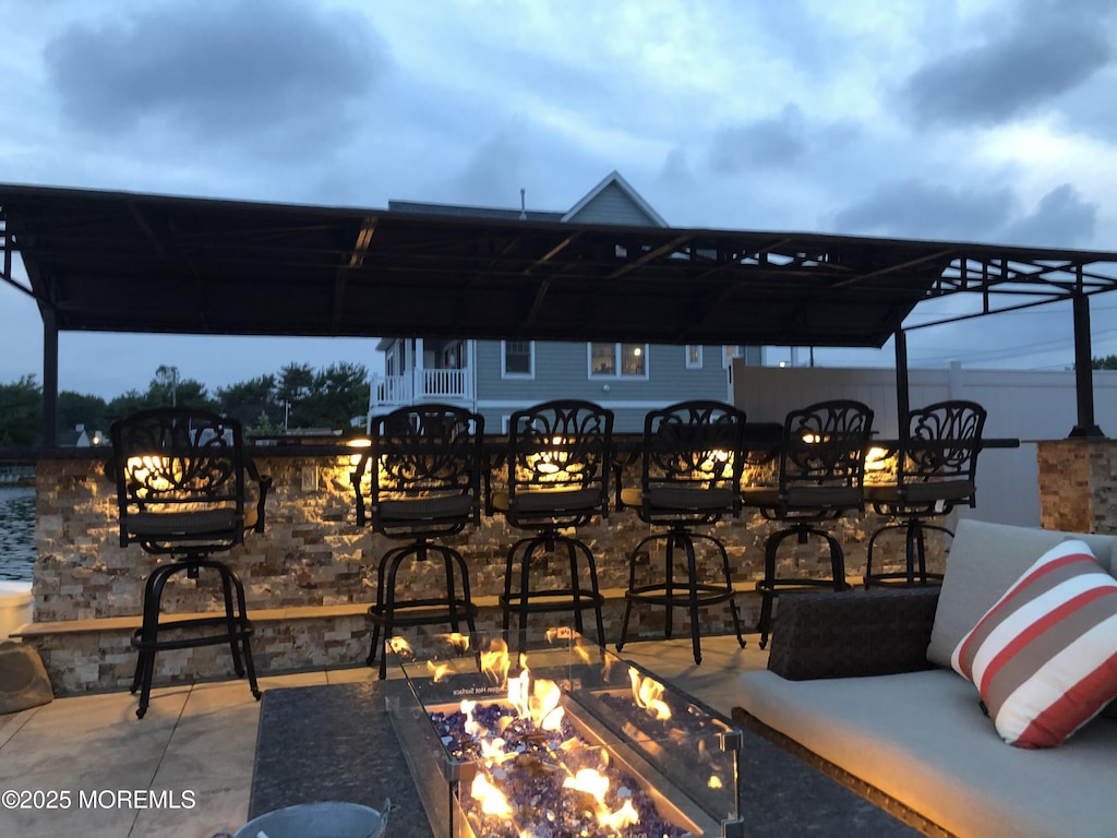 view of patio / terrace featuring a bar and a fire pit