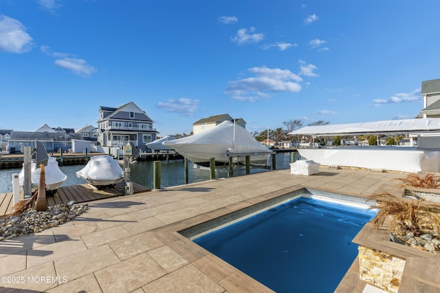 view of pool with a patio area, a boat dock, and a water view