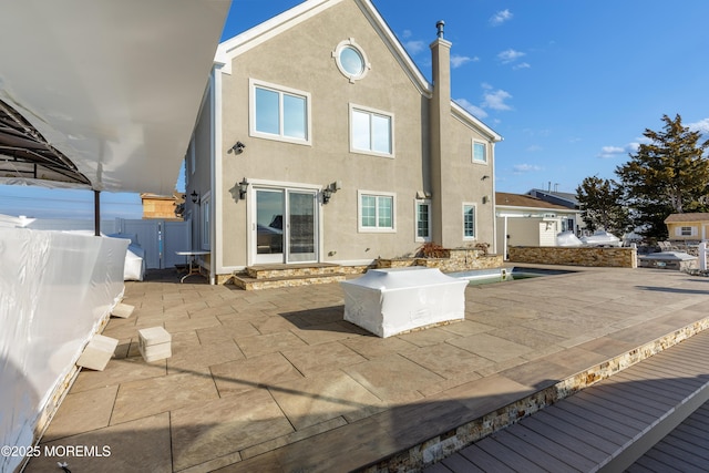 back of house featuring a swimming pool side deck and a patio area