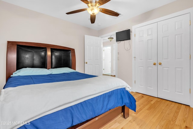 bedroom featuring hardwood / wood-style flooring, ceiling fan, and a closet