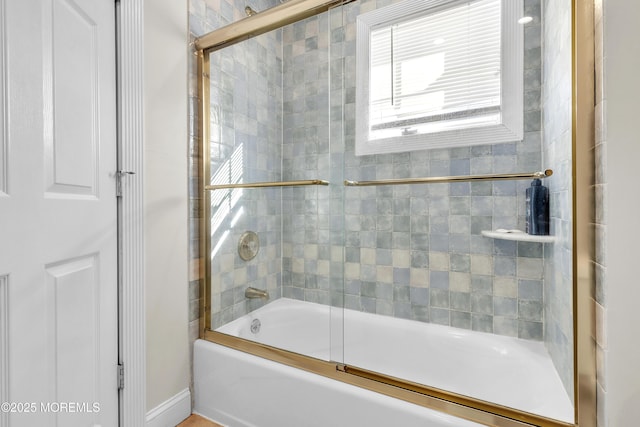 bathroom featuring combined bath / shower with glass door