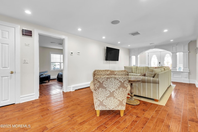 living room featuring french doors, ornate columns, and light hardwood / wood-style flooring