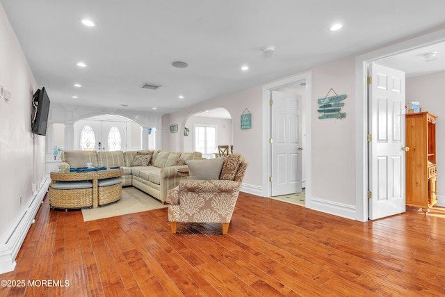 living room featuring light wood-type flooring and baseboard heating