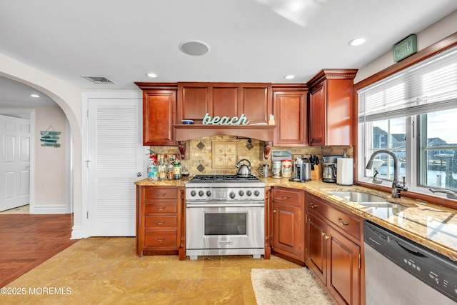 kitchen featuring light stone counters, appliances with stainless steel finishes, sink, and tasteful backsplash