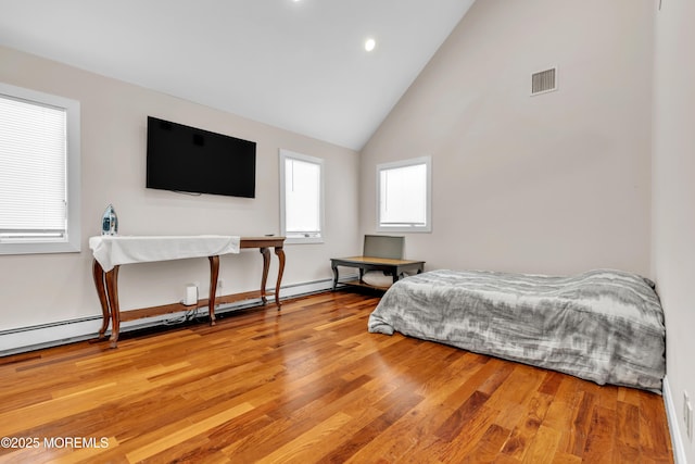 bedroom featuring hardwood / wood-style flooring, a baseboard heating unit, and high vaulted ceiling