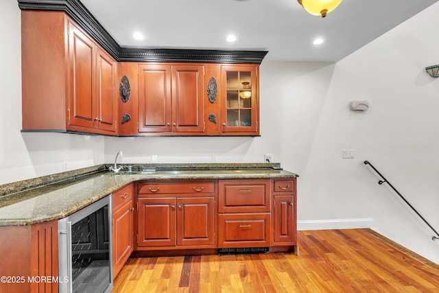 kitchen with wine cooler, light hardwood / wood-style flooring, and dark stone countertops