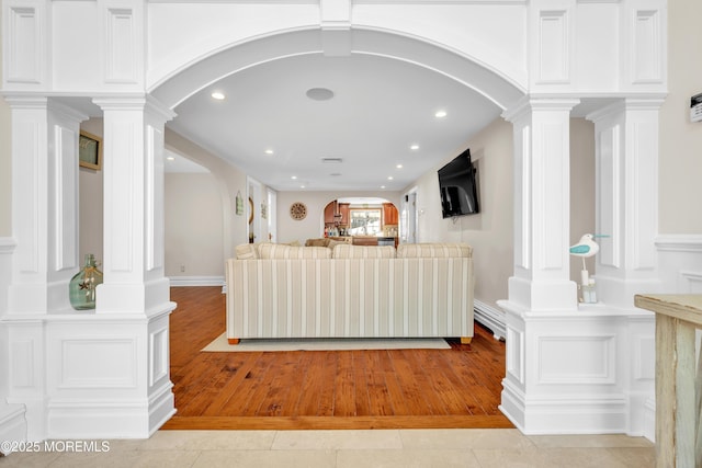 living room featuring decorative columns and light hardwood / wood-style flooring