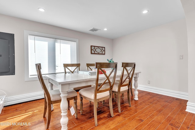 dining area with electric panel and light wood-type flooring