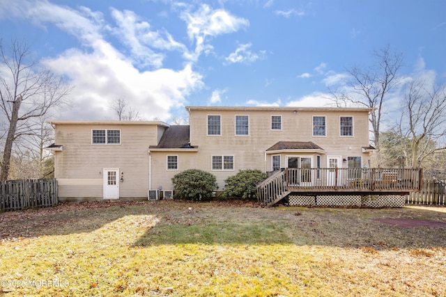 rear view of house featuring a deck, a lawn, and fence