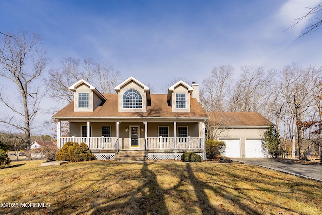 new england style home featuring a garage, a porch, and a front yard