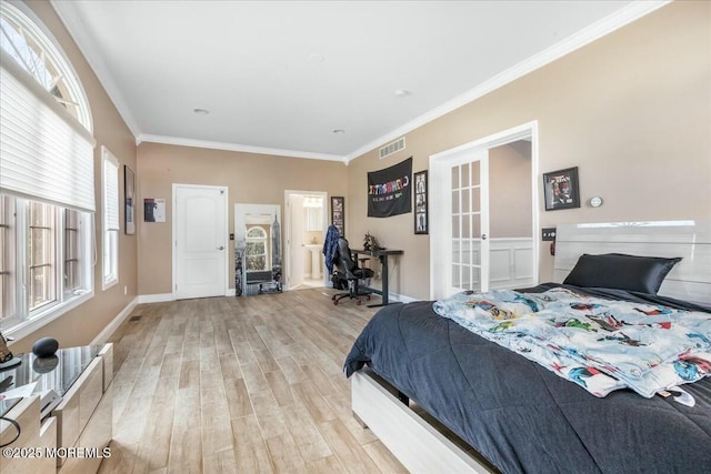 bedroom featuring ornamental molding, ensuite bathroom, and light wood-type flooring