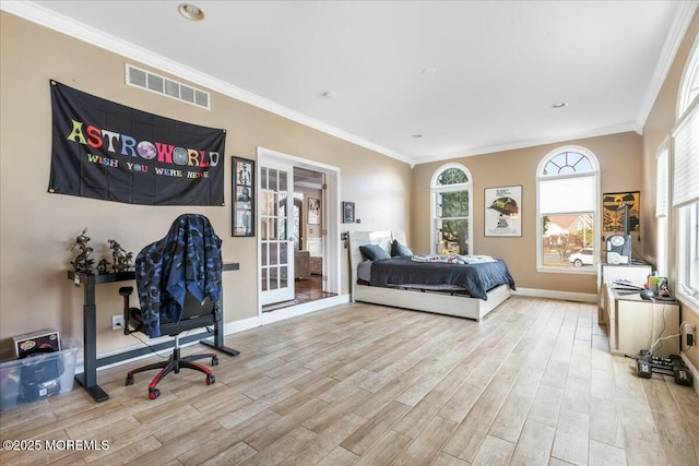 bedroom with crown molding, light hardwood / wood-style floors, and french doors