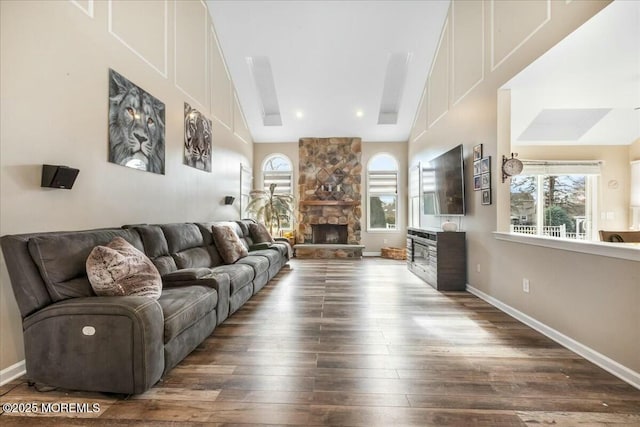 living room with a fireplace, dark hardwood / wood-style flooring, and high vaulted ceiling