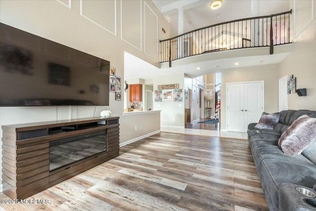 living room featuring a high ceiling and light wood-type flooring