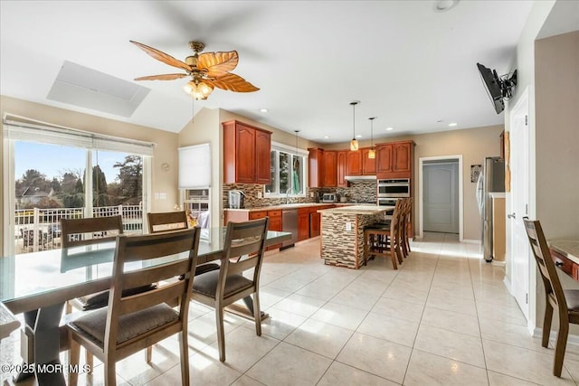 tiled dining room with ceiling fan and sink