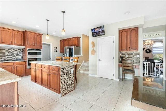 kitchen featuring a kitchen island, appliances with stainless steel finishes, pendant lighting, tasteful backsplash, and light tile patterned floors