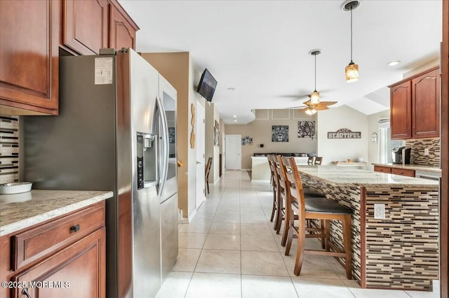 kitchen with light tile patterned flooring, decorative light fixtures, backsplash, ceiling fan, and stainless steel refrigerator with ice dispenser