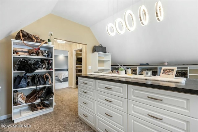 walk in closet featuring light carpet and lofted ceiling