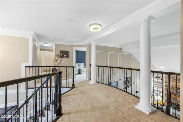 hallway with ornate columns, crown molding, and carpet