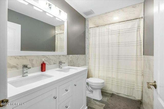 bathroom with vanity, tile walls, curtained shower, and toilet