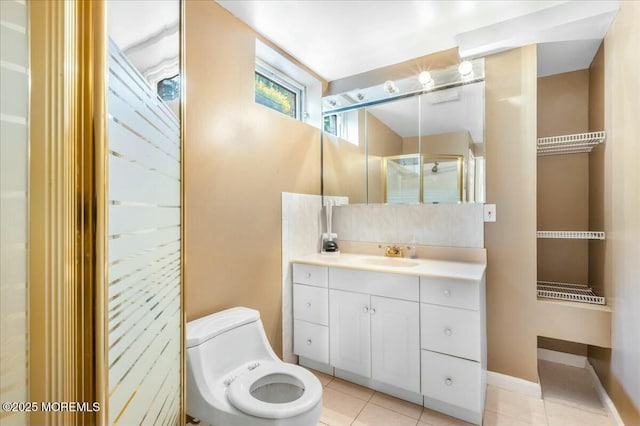 bathroom with tile patterned flooring, vanity, an enclosed shower, and toilet