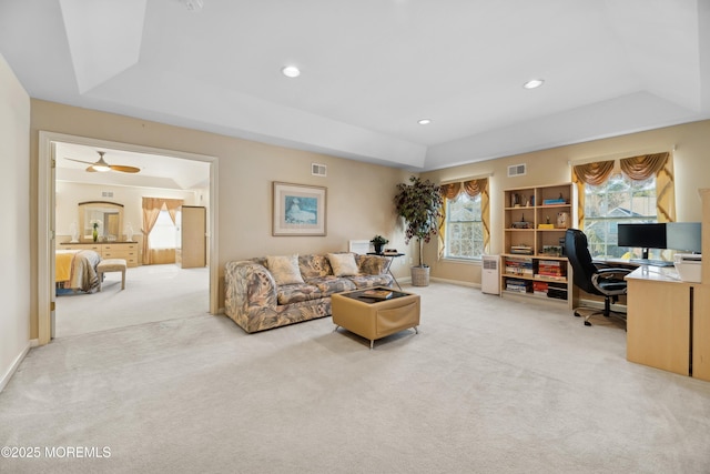 carpeted living room with a tray ceiling