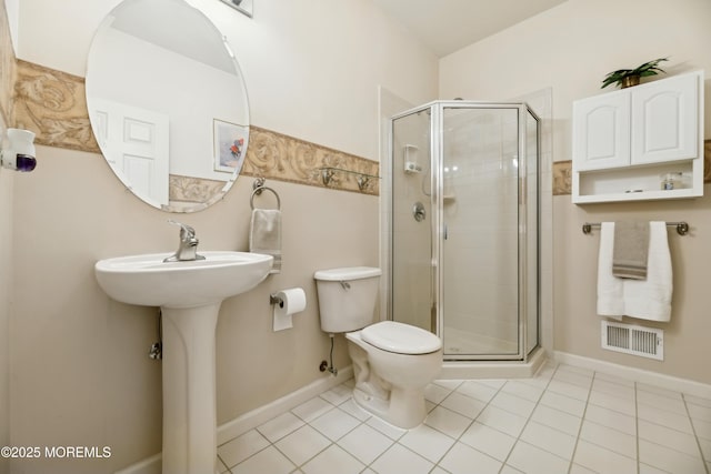 bathroom featuring tile patterned floors, toilet, and an enclosed shower