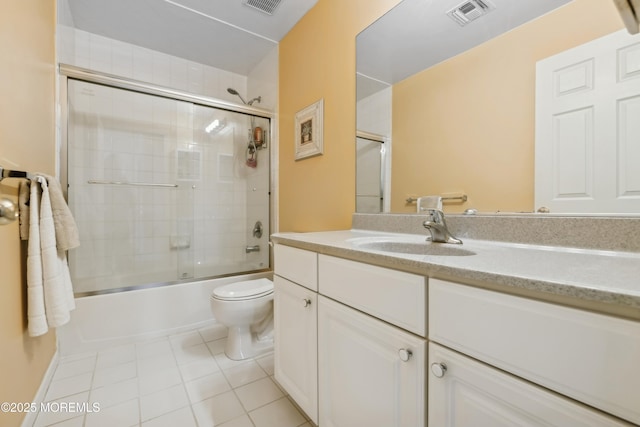 full bathroom featuring enclosed tub / shower combo, vanity, toilet, and tile patterned flooring