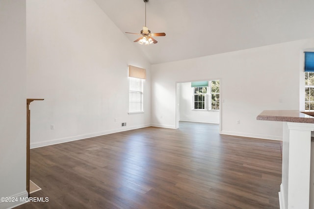 unfurnished living room with ceiling fan, dark hardwood / wood-style floors, and high vaulted ceiling