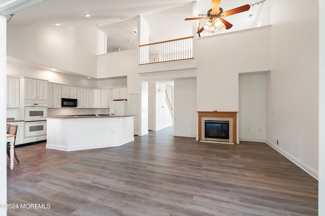 kitchen with white cabinetry, dark hardwood / wood-style floors, ceiling fan, and white appliances