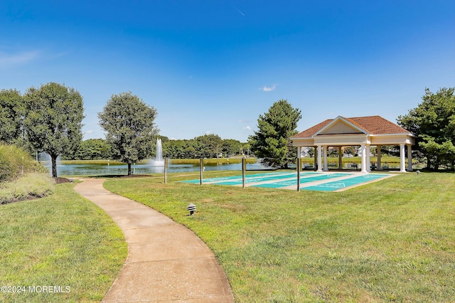 view of swimming pool featuring a water view and a lawn