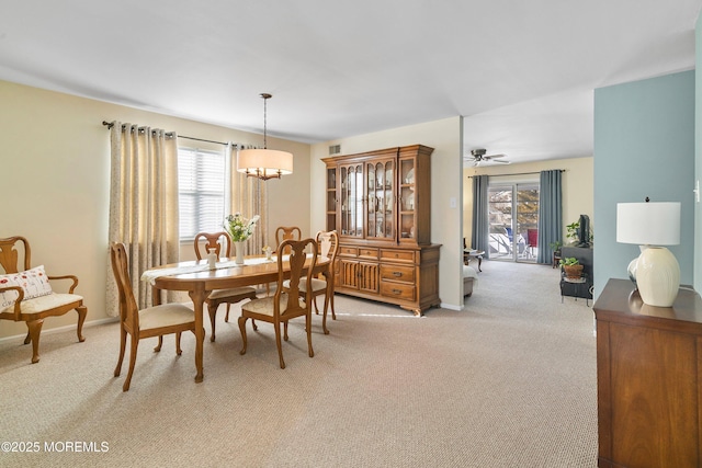 dining space with a wealth of natural light, light colored carpet, and ceiling fan