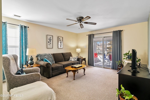 carpeted living room with ceiling fan