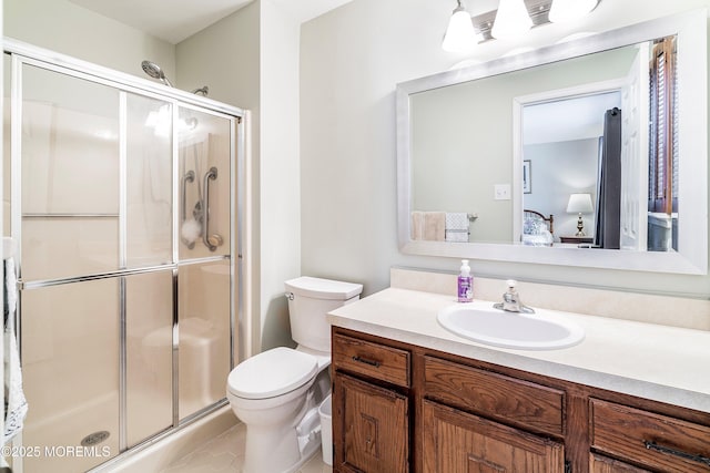 bathroom with vanity, toilet, and a shower with door