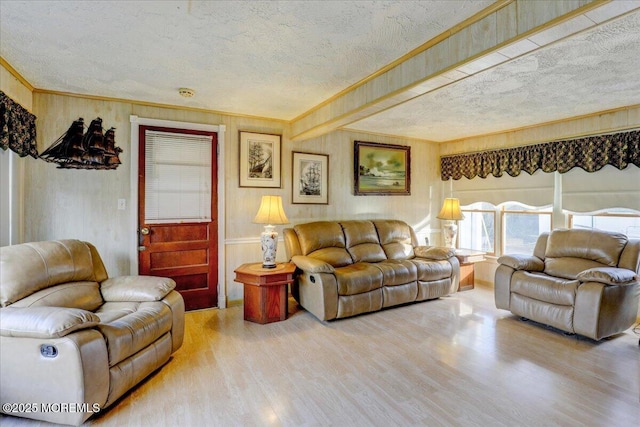 living room featuring crown molding, wood-type flooring, and a textured ceiling