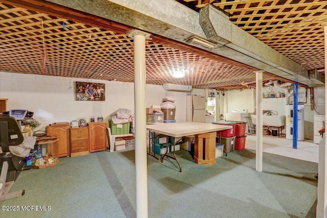 basement with white refrigerator, sink, washer / dryer, and electric water heater