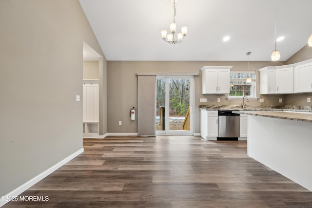 kitchen with vaulted ceiling, white cabinets, decorative light fixtures, and dishwasher