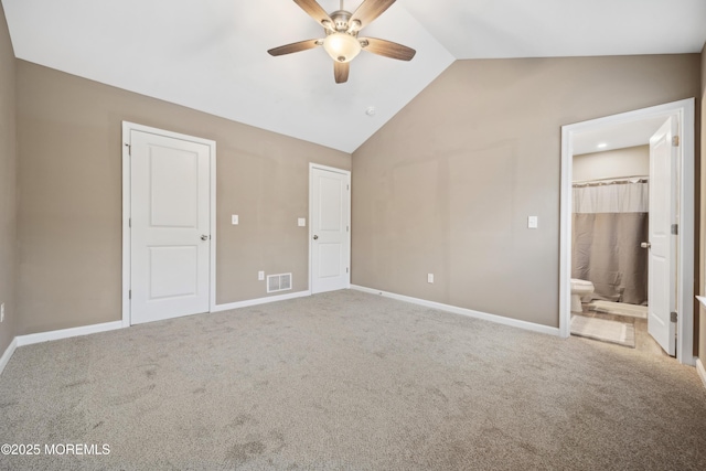 unfurnished bedroom with ensuite bathroom, lofted ceiling, carpet flooring, and ceiling fan