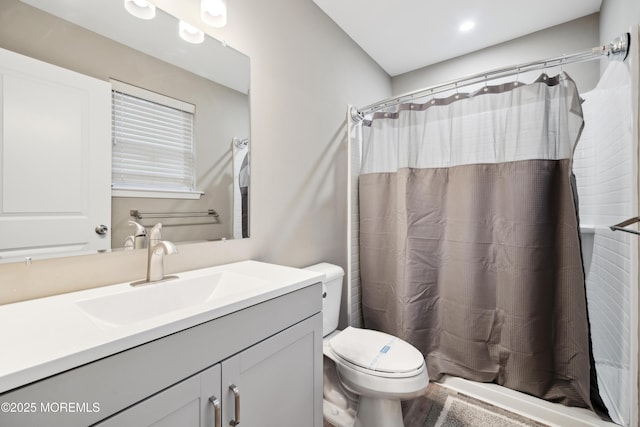 bathroom with toilet, vanity, and curtained shower