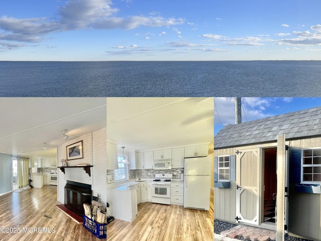 exterior space with white appliances, light wood-type flooring, white cabinets, and a water view