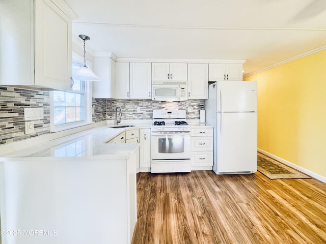 kitchen with sink, crown molding, white appliances, hanging light fixtures, and white cabinets